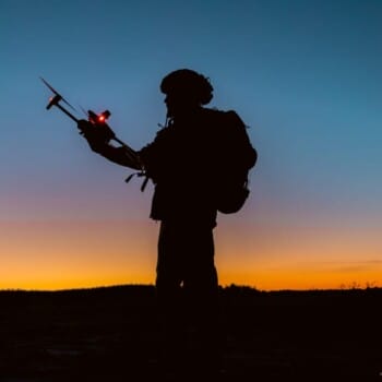 A soldier using a drone for scouting during a military operation.