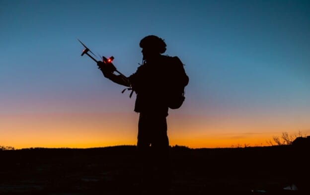A soldier using a drone for scouting during a military operation.